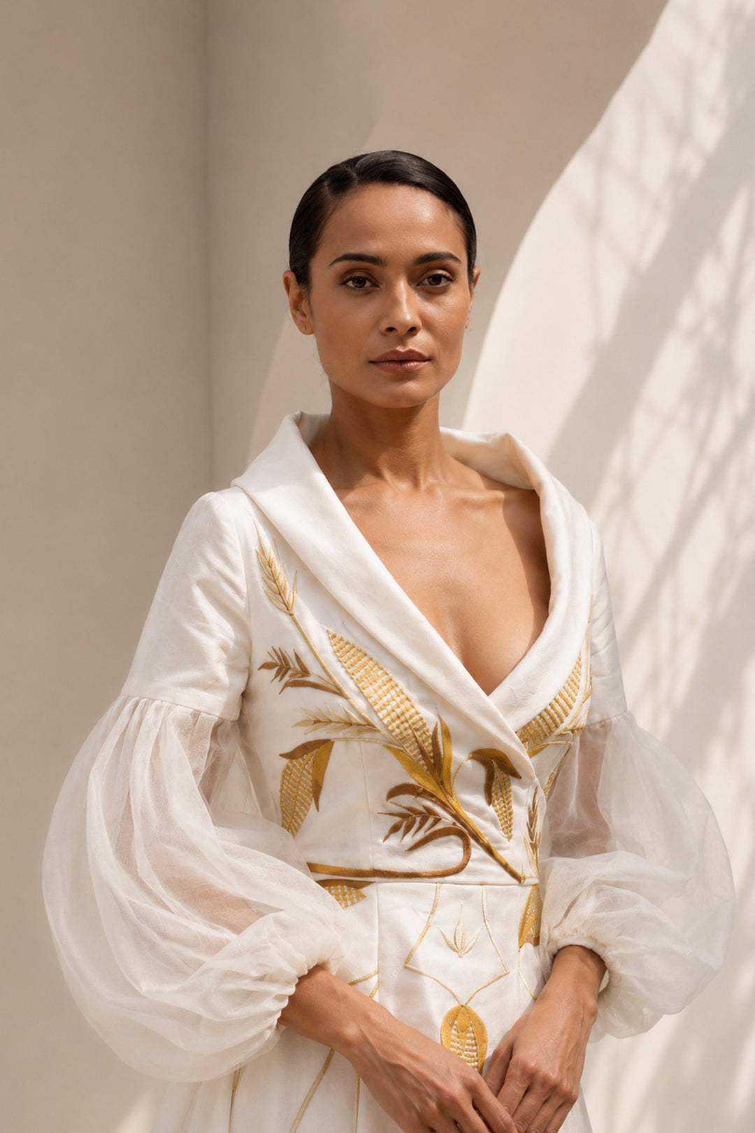 Ivory gown featuring statement sleeves, elegant shwal collar neckline and nature inspired motif embroidery.
