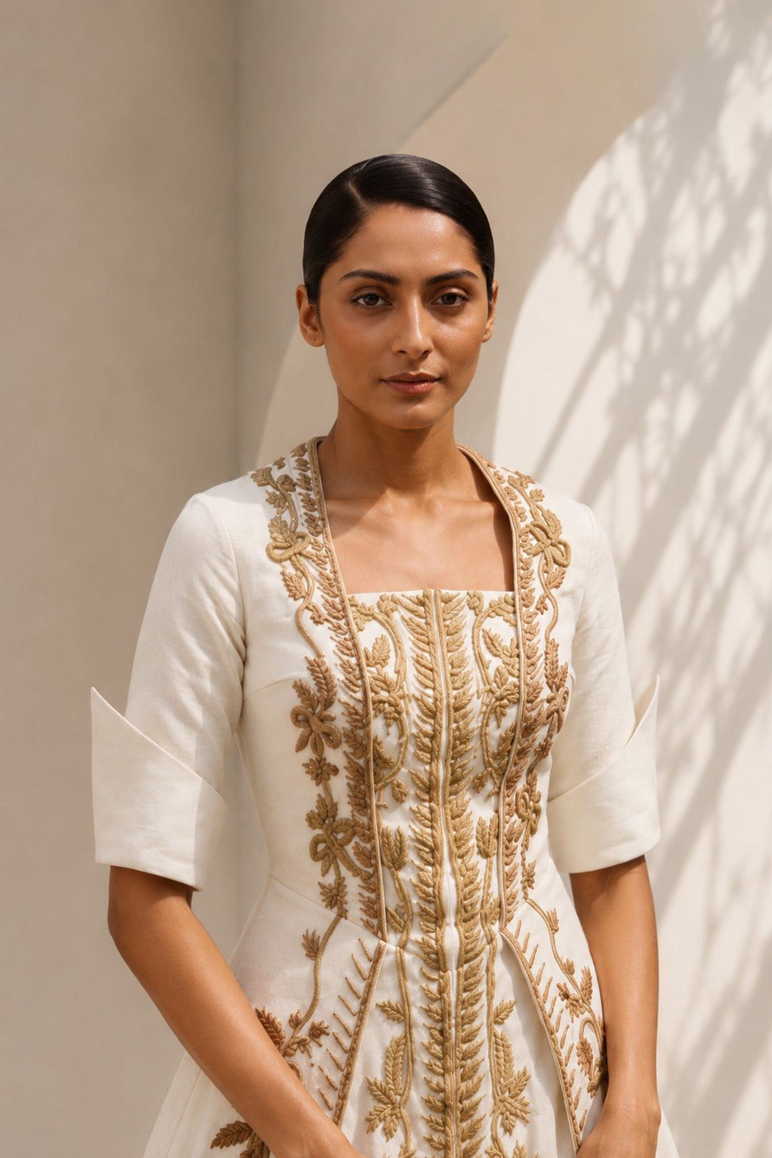 Ivory embroidered panel gown featuring elegant square neckline, structured bodice &amp; antique gold handcrafted threadwork.