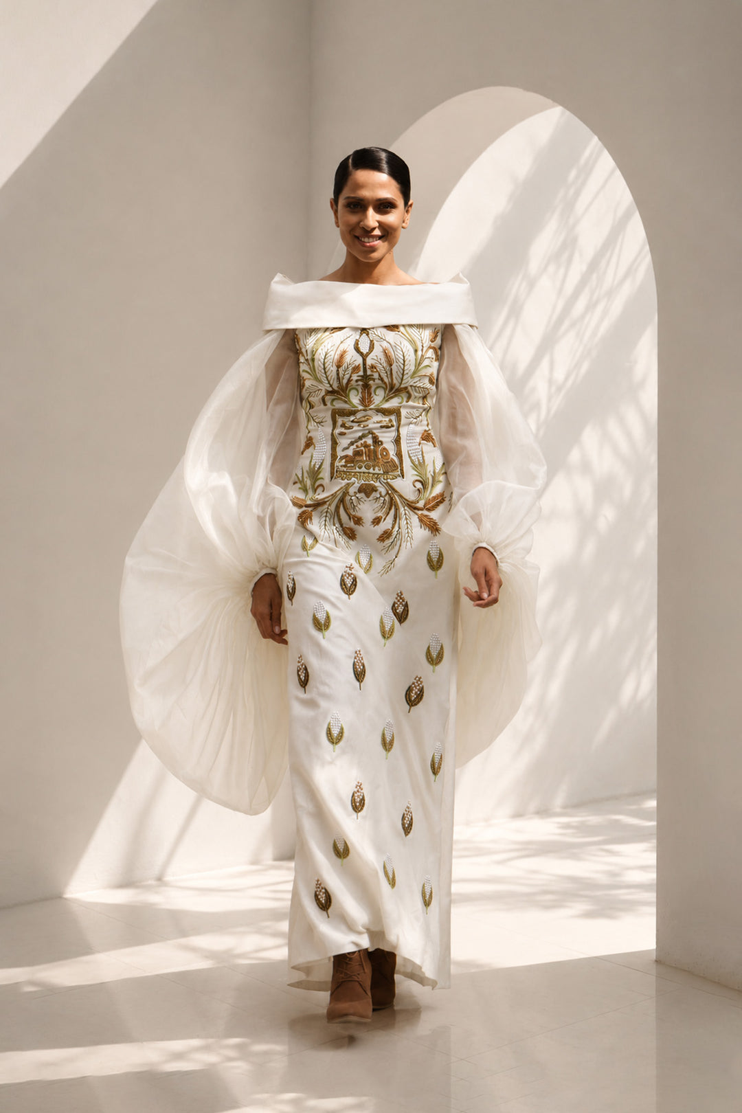 Ivory embroidered column gown featuring an elegant off-shoulder neckline, voluminous sheer sleeves.