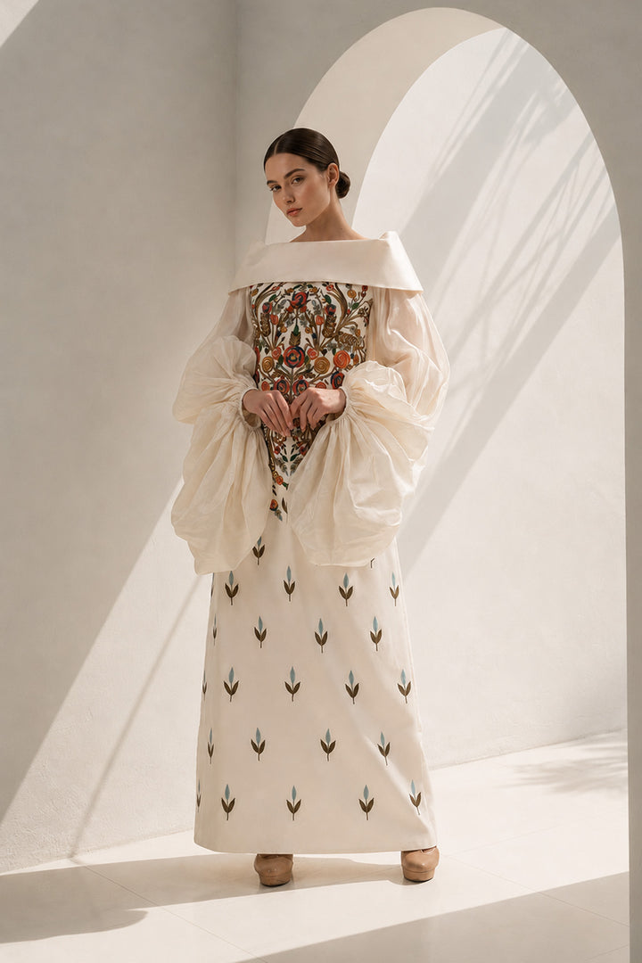 Ivory gown featuring a richly embroidered floral bodice, dramatic sheer organza sleeves, and a graceful off-shoulder neckline.