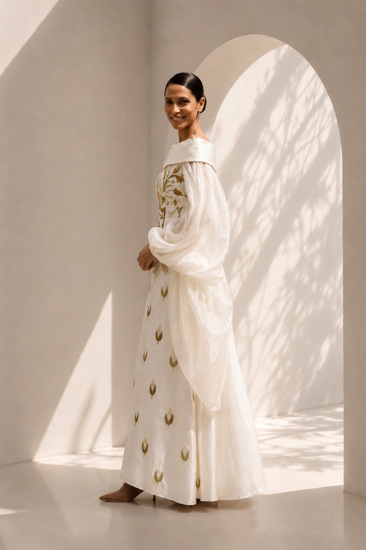Ivory embroidered column gown featuring an elegant off-shoulder neckline, voluminous sheer sleeves.