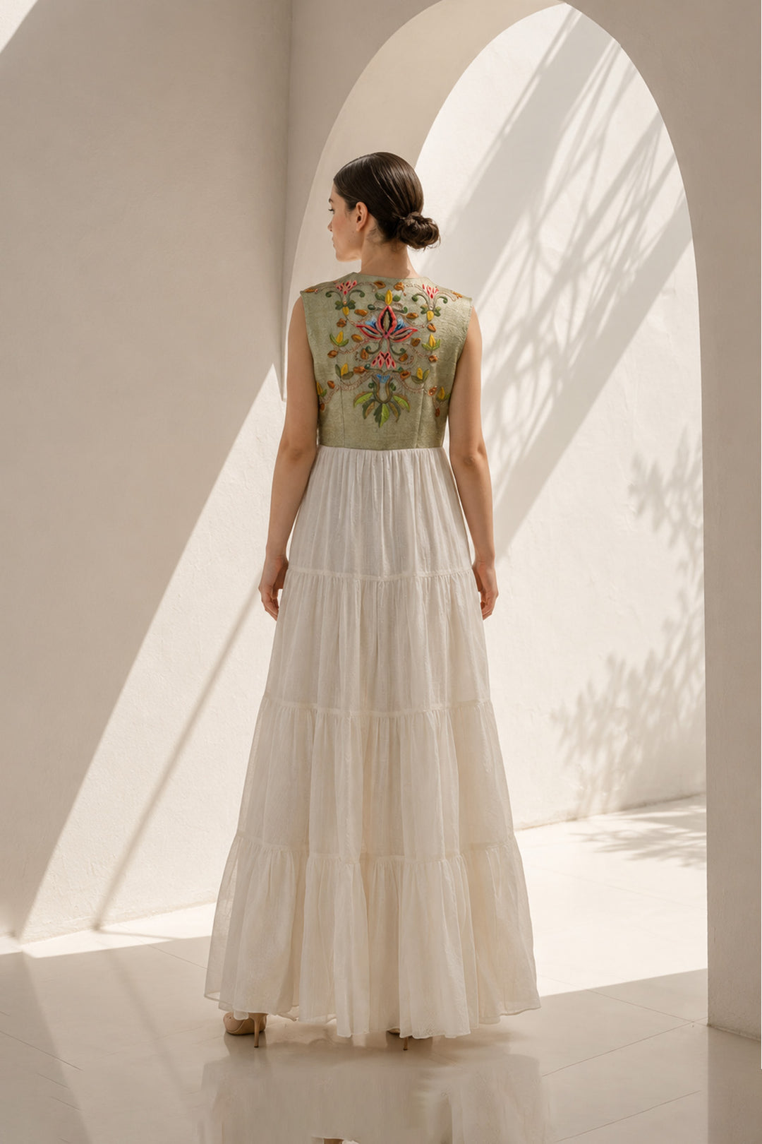 Ivory maxi dress featured with sage green embroidered sleeveless jacket.