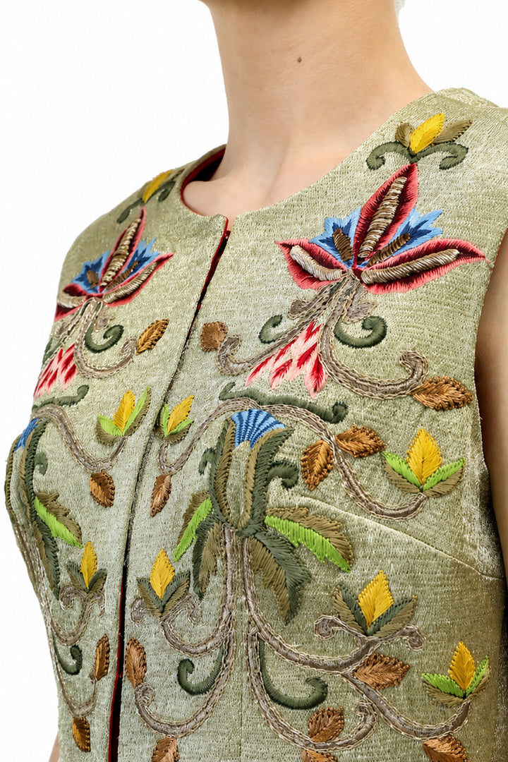 Ivory maxi dress featured with sage green embroidered sleeveless jacket.