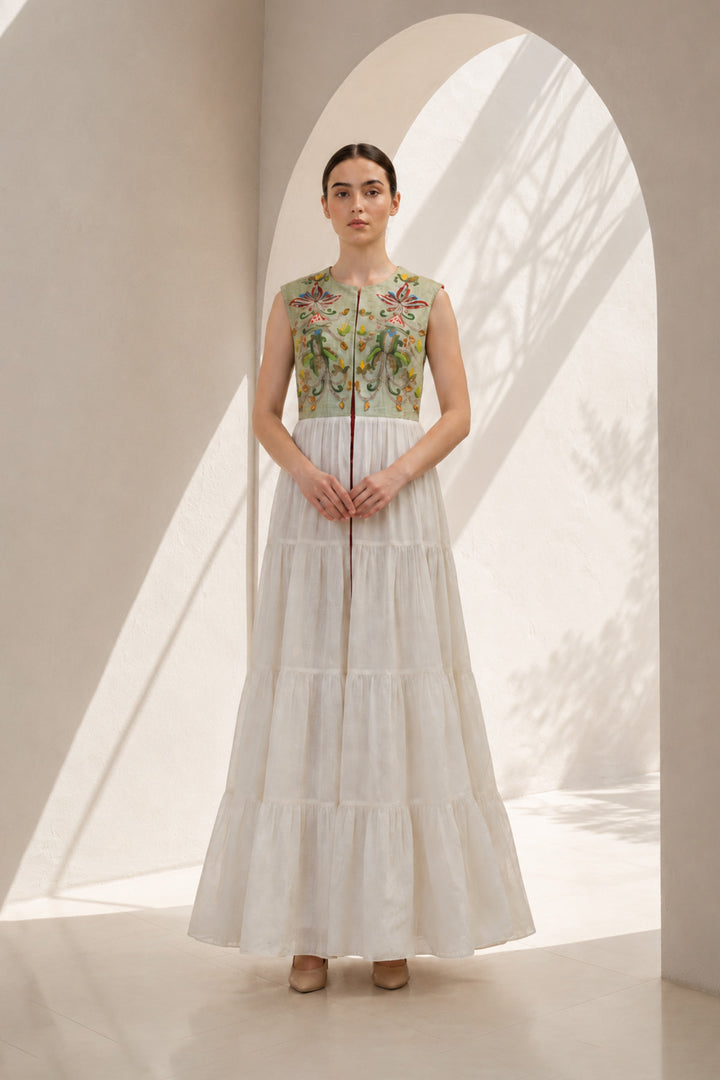Ivory maxi dress featured with sage green embroidered sleeveless jacket.