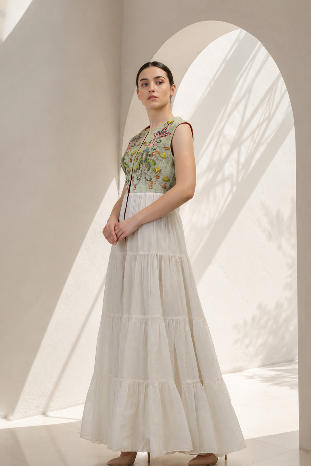 Ivory maxi dress featured with sage green embroidered sleeveless jacket.