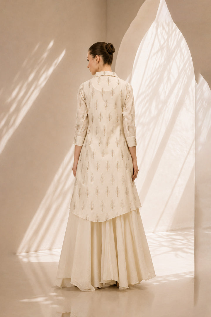 Ivory layered ensemble featuring a delicately printed overlay and flowing drape.