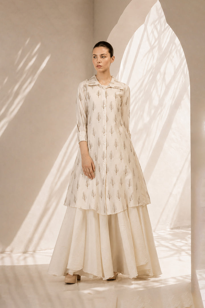 Ivory layered ensemble featuring a delicately printed overlay and flowing drape.