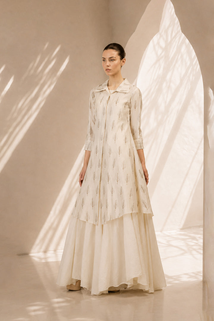 Ivory layered ensemble featuring a delicately printed overlay and flowing drape.