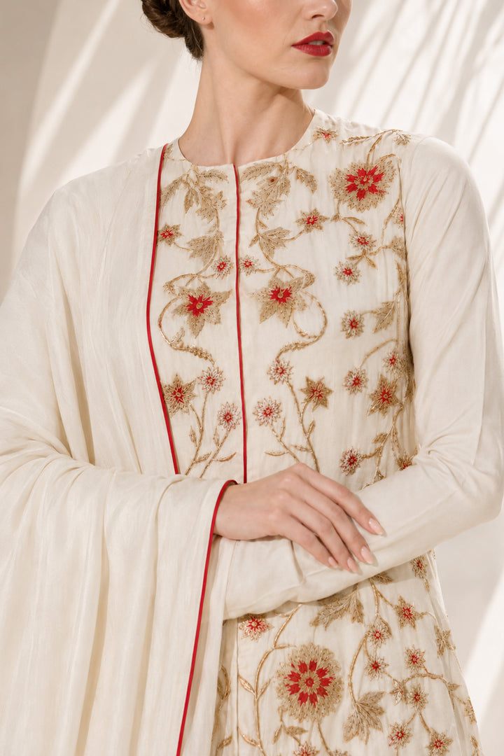 Ivory kurta set adorned with delicate floral embroidery, paired with a tiered sharara and embroidered dupatta.