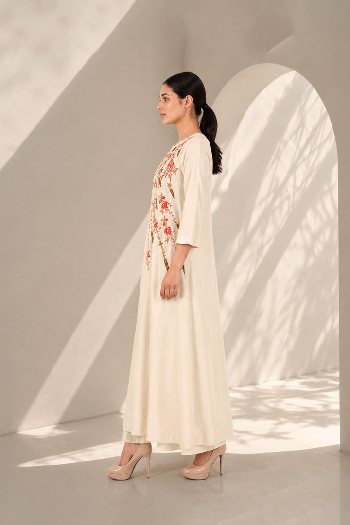 Ivory A-line dress featuring classic round neckline &amp; adorned with intricate floral embroidery.