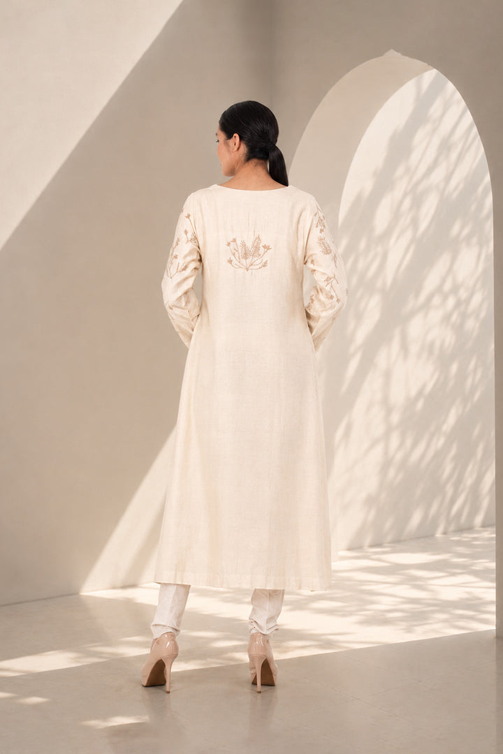 Ivory kurta set featuring delicate botanical prints, designed with a graceful straight silhouette, classic round neckline, full-length sleeves.