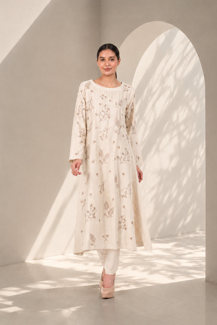 Ivory kurta set featuring delicate botanical prints, designed with a graceful straight silhouette, classic round neckline, full-length sleeves.