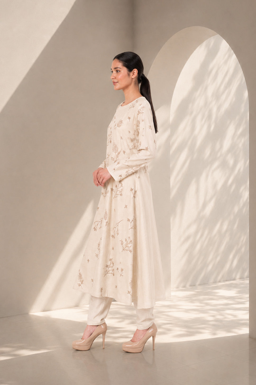 Ivory kurta set featuring delicate botanical prints, designed with a graceful straight silhouette, classic round neckline, full-length sleeves.