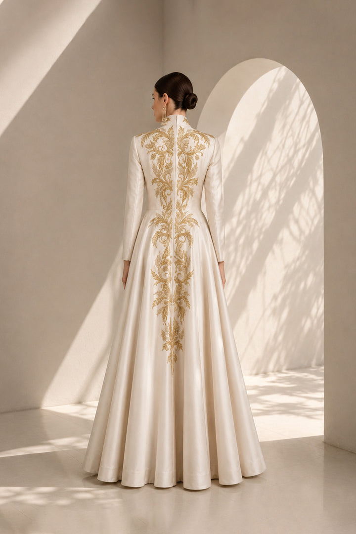 Ivory embroidered gown featuring an architectural plunging neckline, full-sleeved, structured bodice, voluminous flared hem.