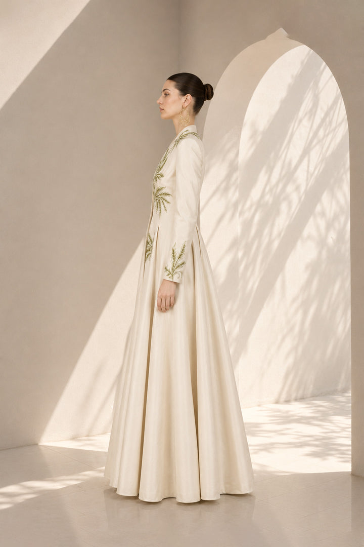 Ivory embroidered gown featuring a dramatic deep V-neckline, full-sleeves with embroidered cuffs, concealed side pockets.