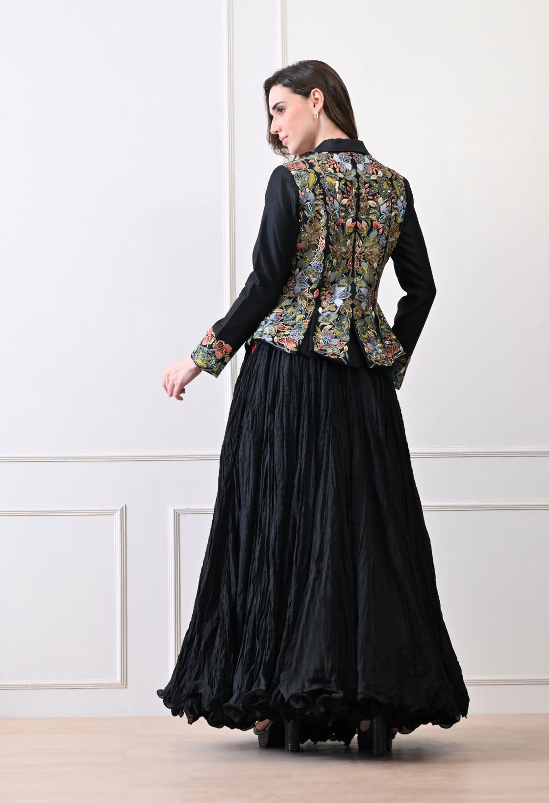 A black jacket features intricate all-over embroidery with skirt