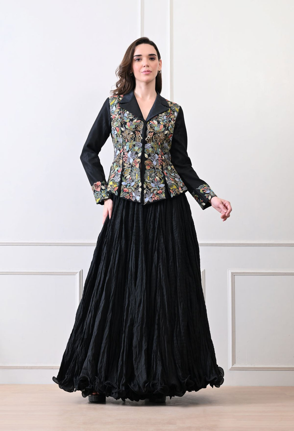 A black jacket features intricate all-over embroidery with skirt