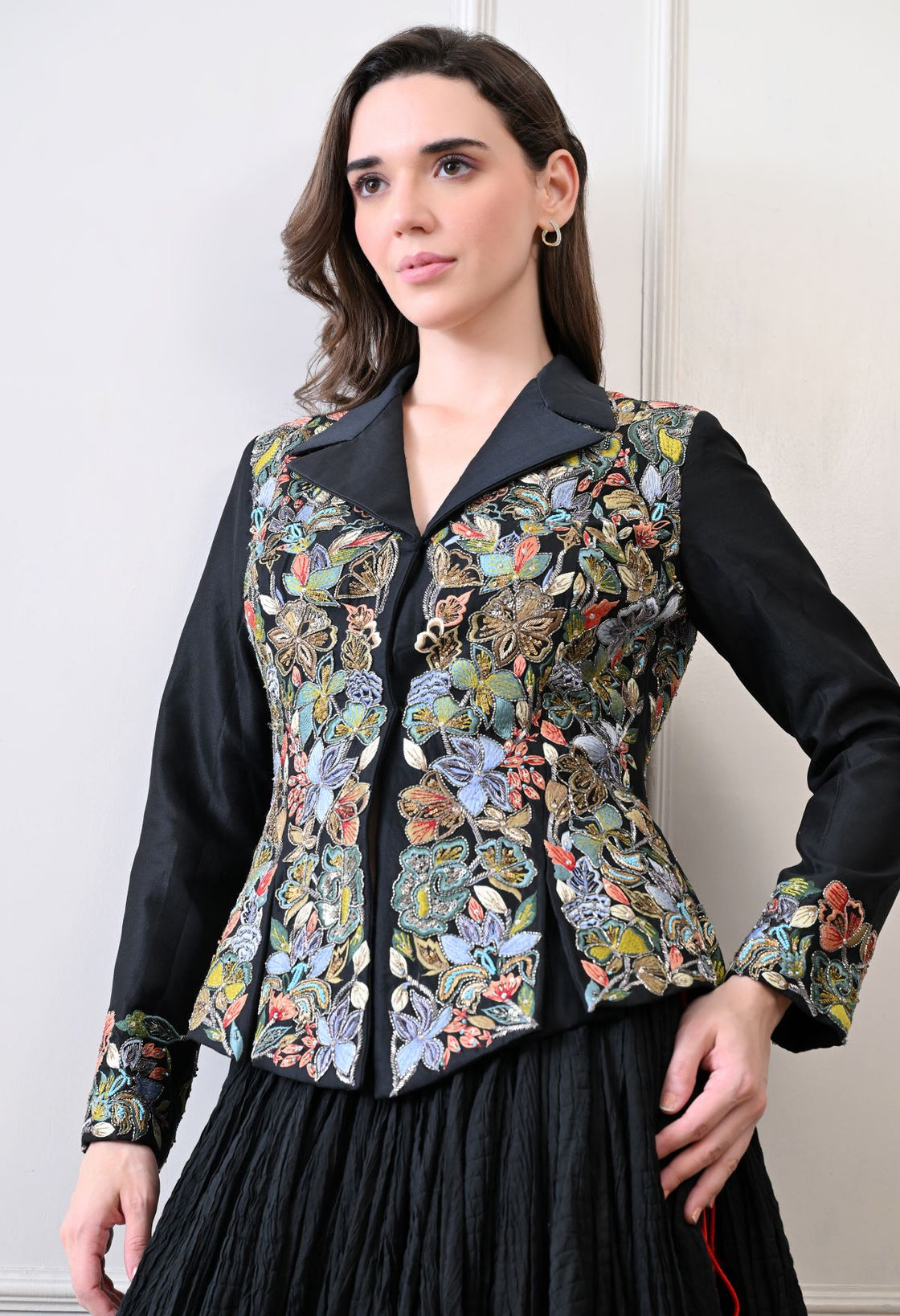 A black jacket features intricate all-over embroidery with skirt