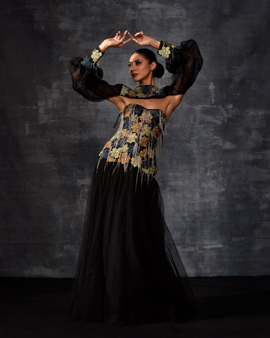 A elegant black off-shoulder gown features a dramatic sleeve top.