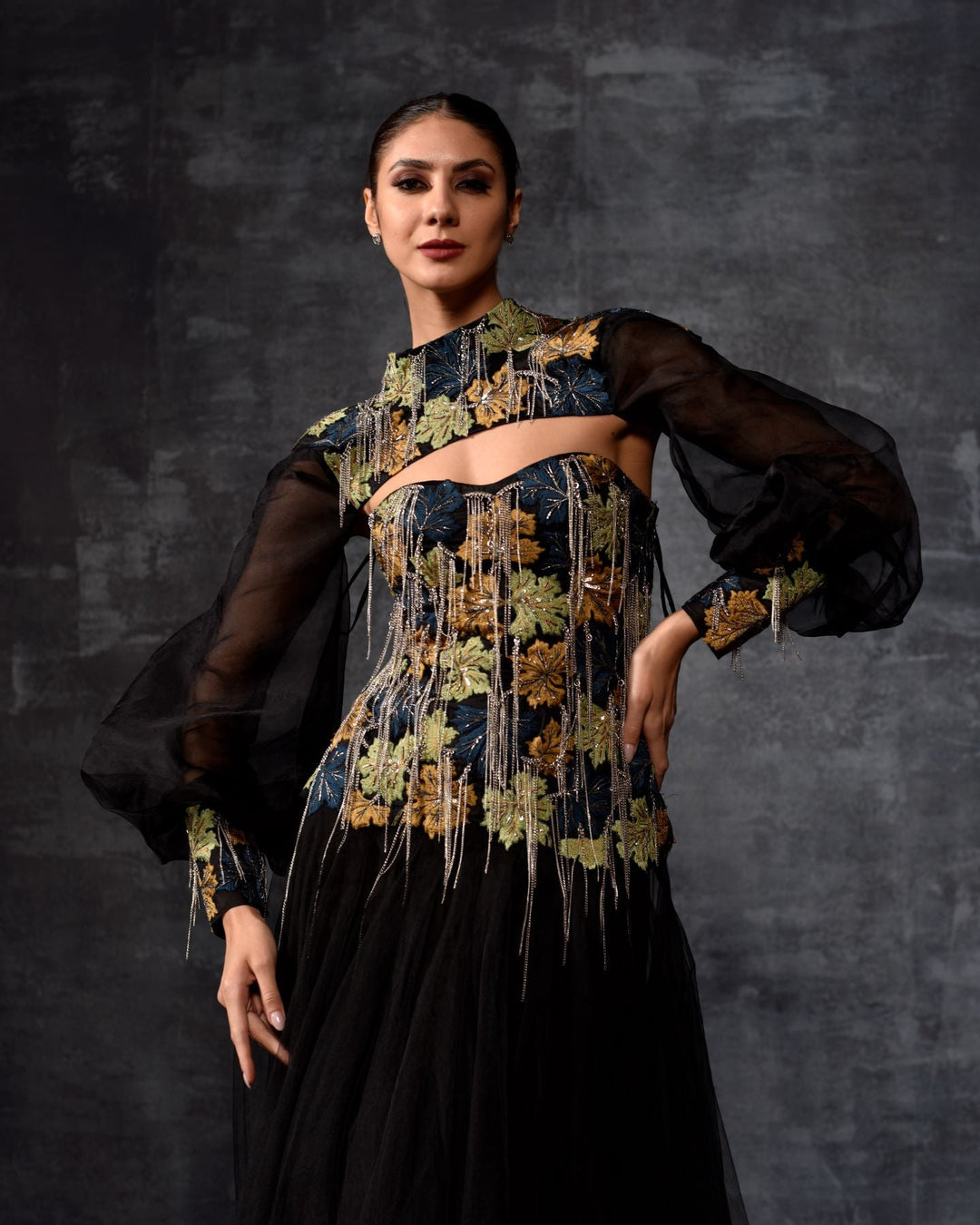 A elegant black off-shoulder gown features a dramatic sleeve top.