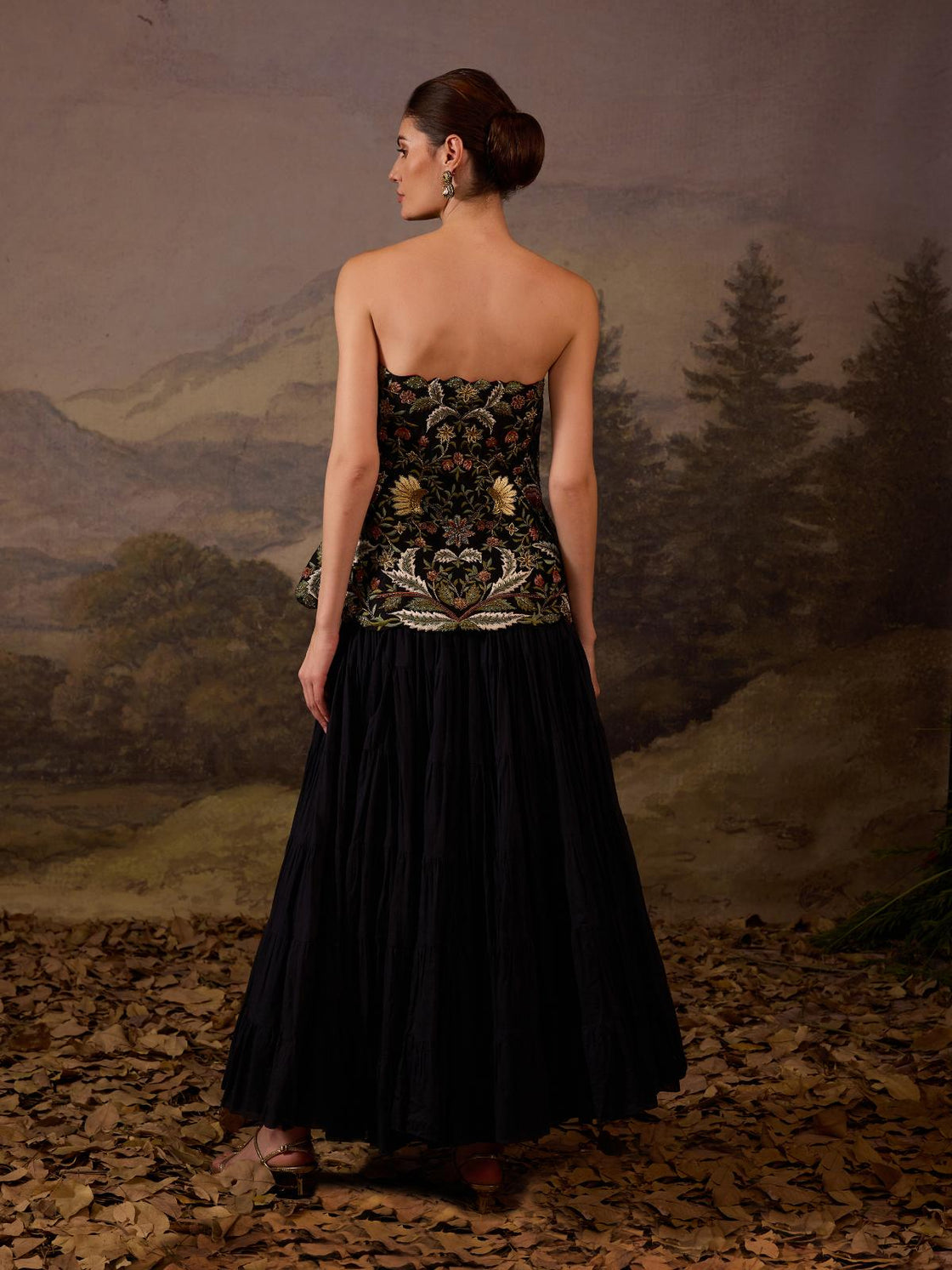 A elegant ensemble features a strapless corset embroidered with floral motif.