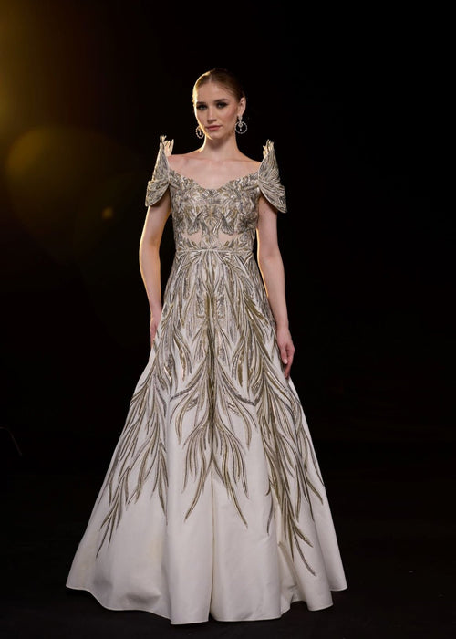 A elegant gown features an off-shoulder design with structured sleeves.