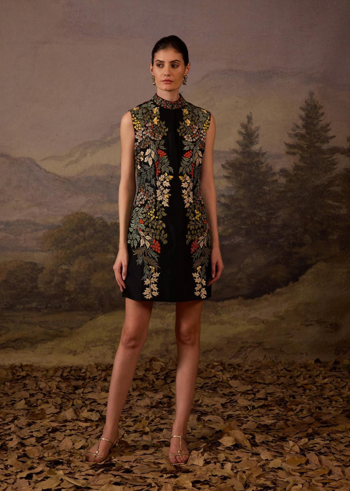 A sleeveless black mini dress features a high neckline and vibrant floral embroidery.
