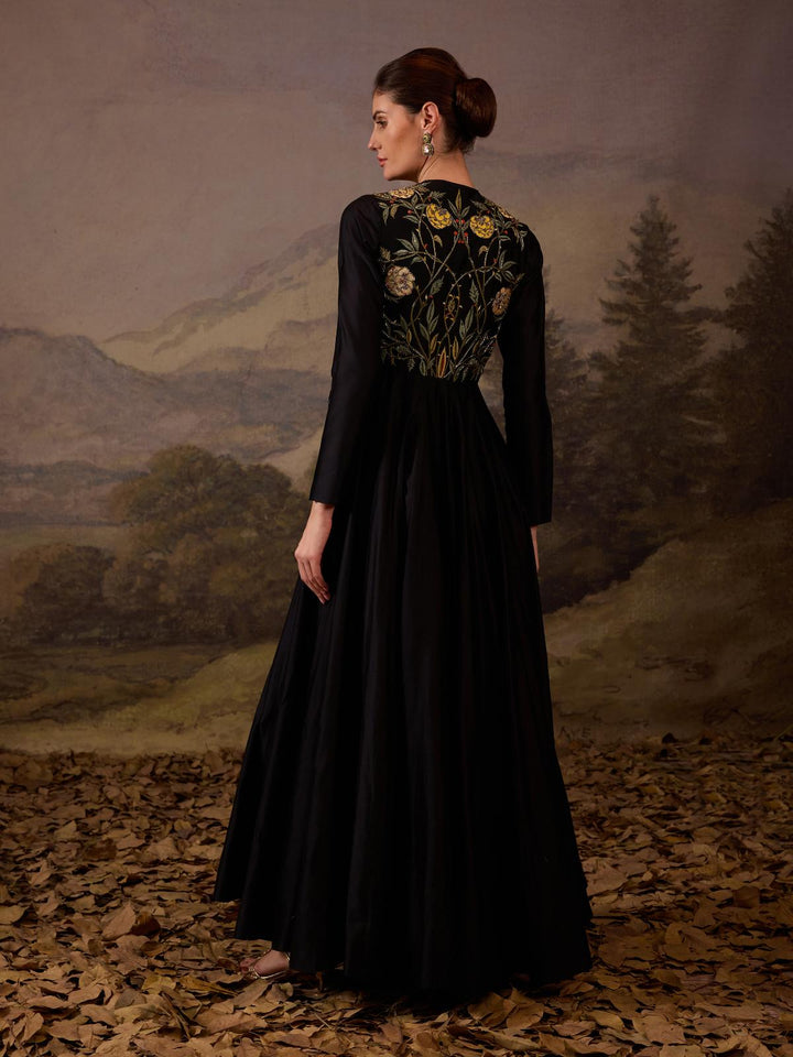 A sophisticated long black dress showcasing subtle floral embroidery.