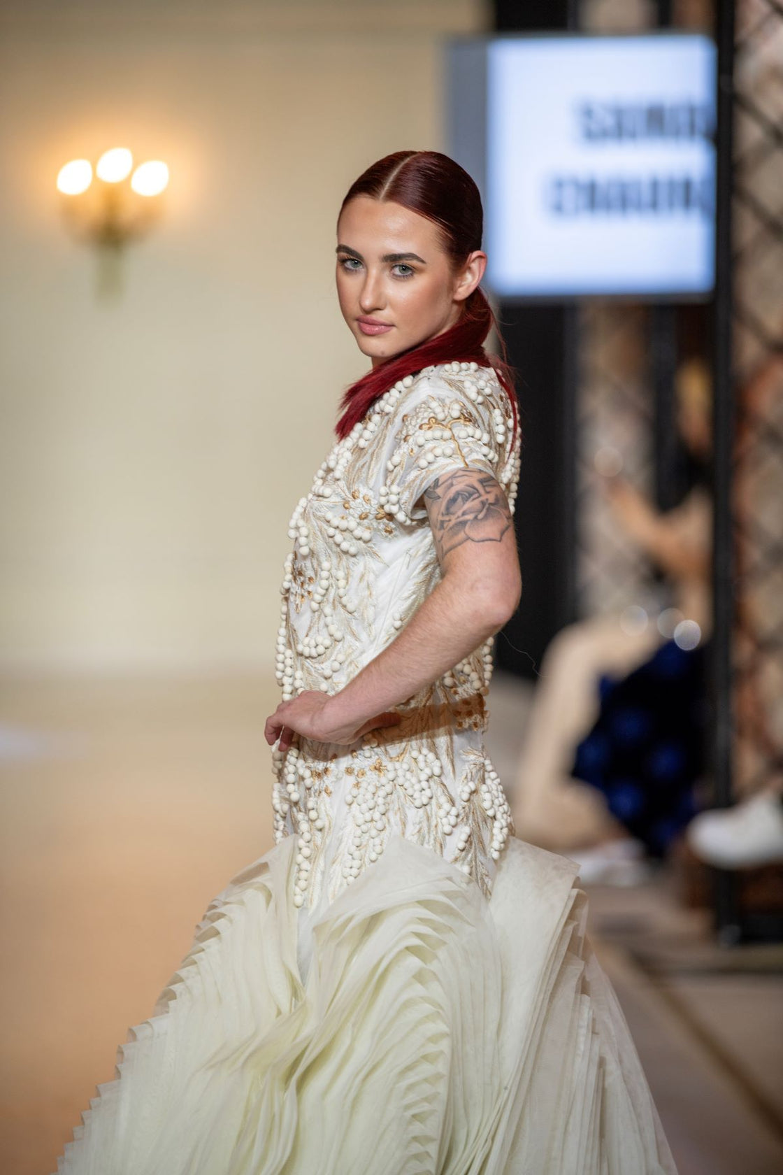 A exquisite gown features a sculpted bodice with ornate bead and thread embroidery