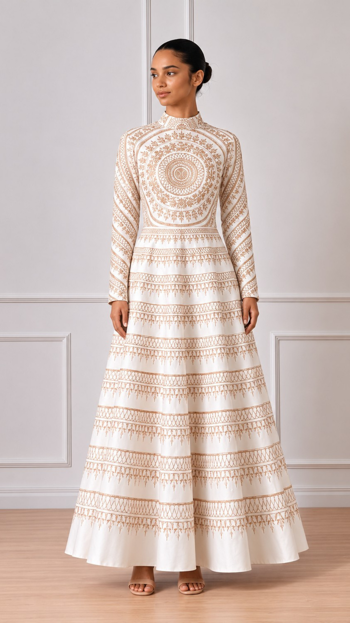 Woman wearing a long, patterned dress against a white paneled wall.