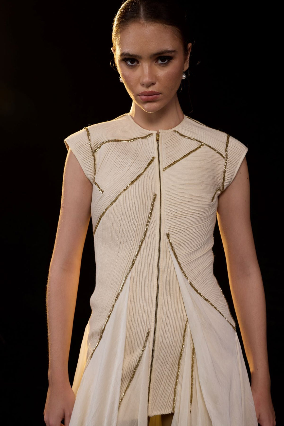 Ivory structured gown with a sculpted bodice and flowing layered panels.