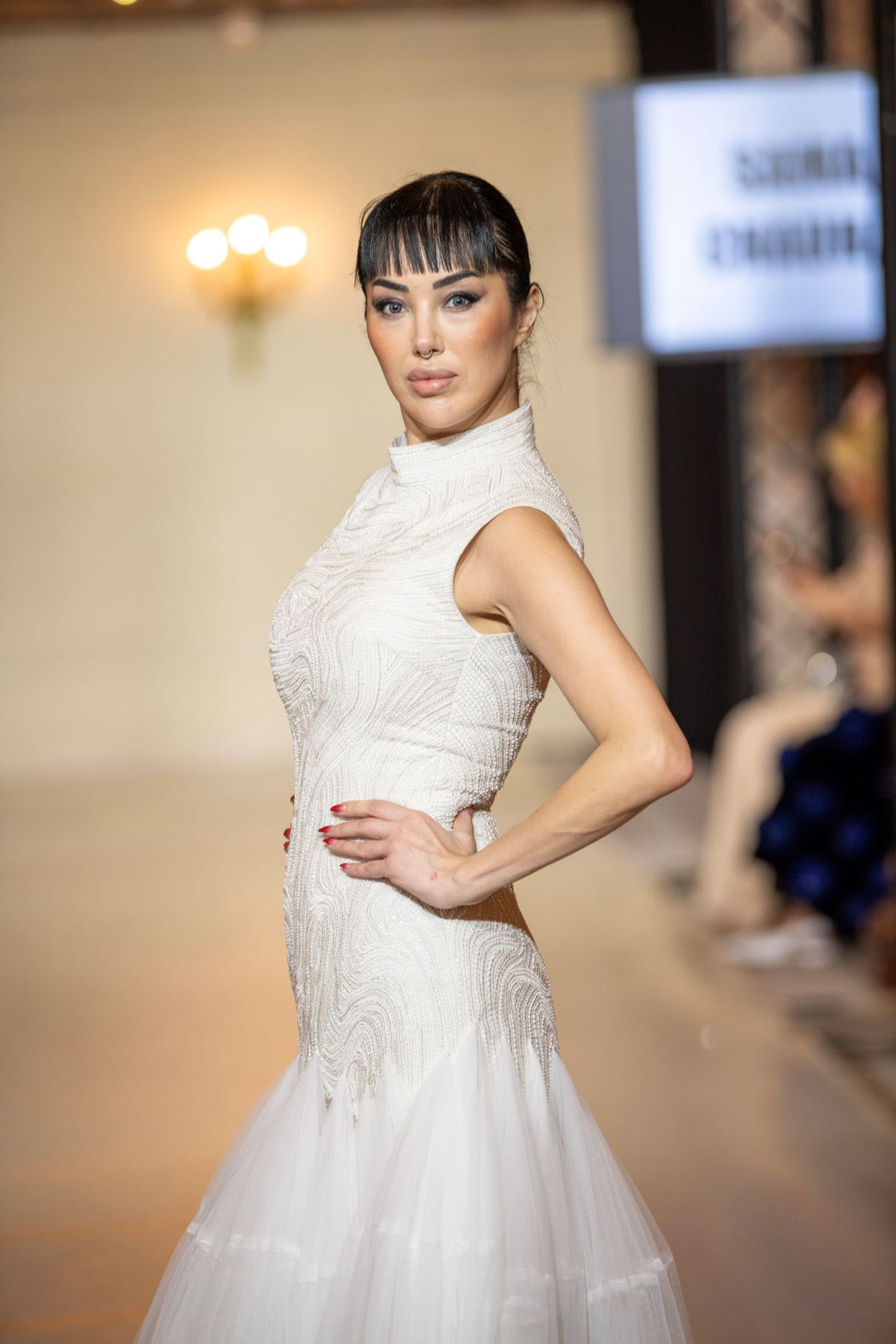 A elegant sleeveless gown features a high neckline and a fitted