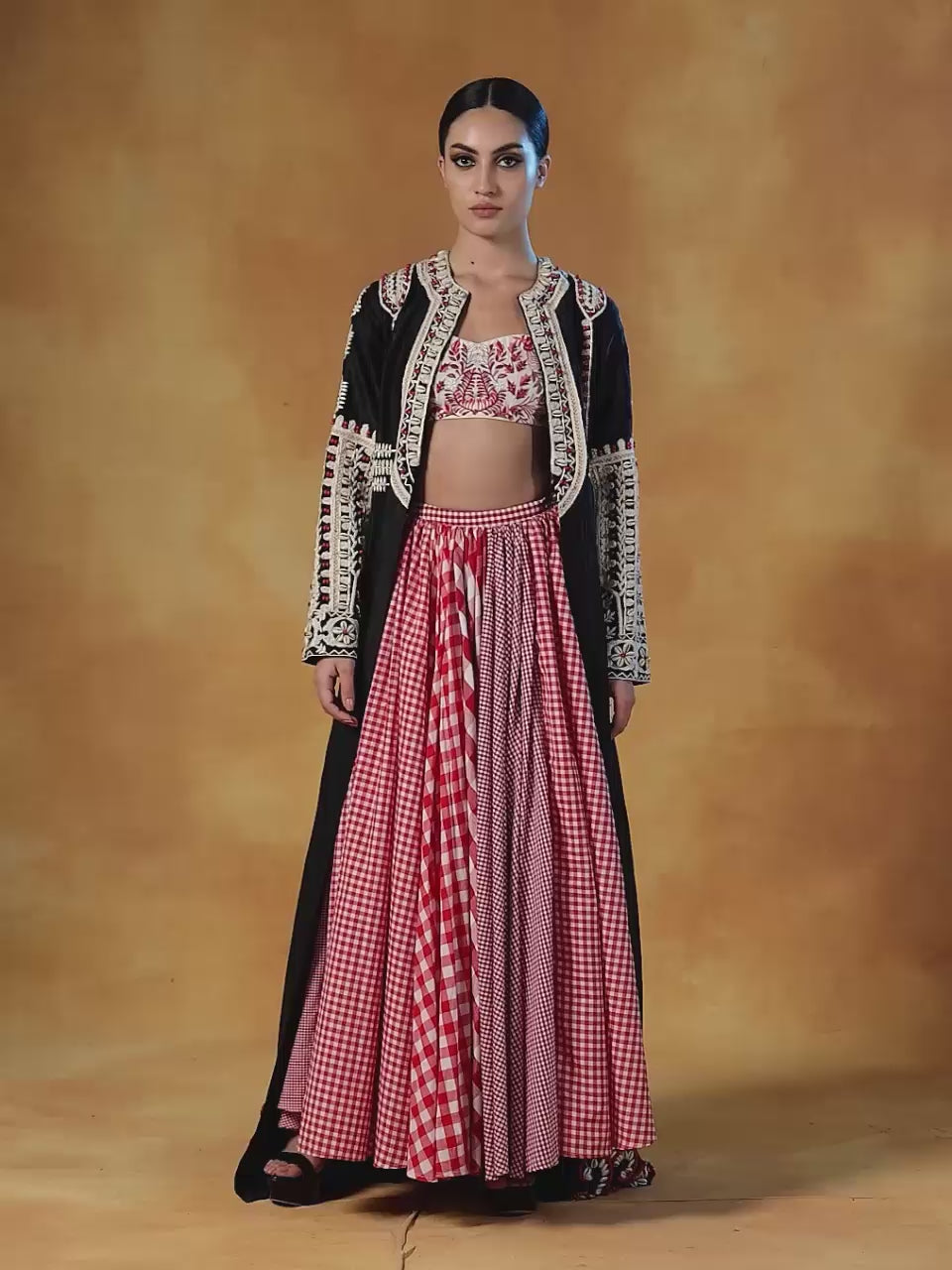 Jacket is topped over a check skirt and embroidered blouse