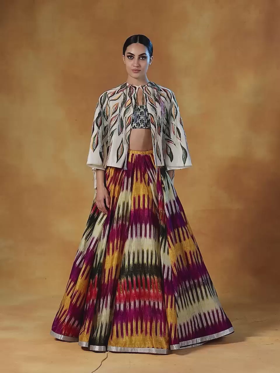 printed cotton silk skirt topped with an off-white cape style waist jacket covered with patchwork with a bustier inside