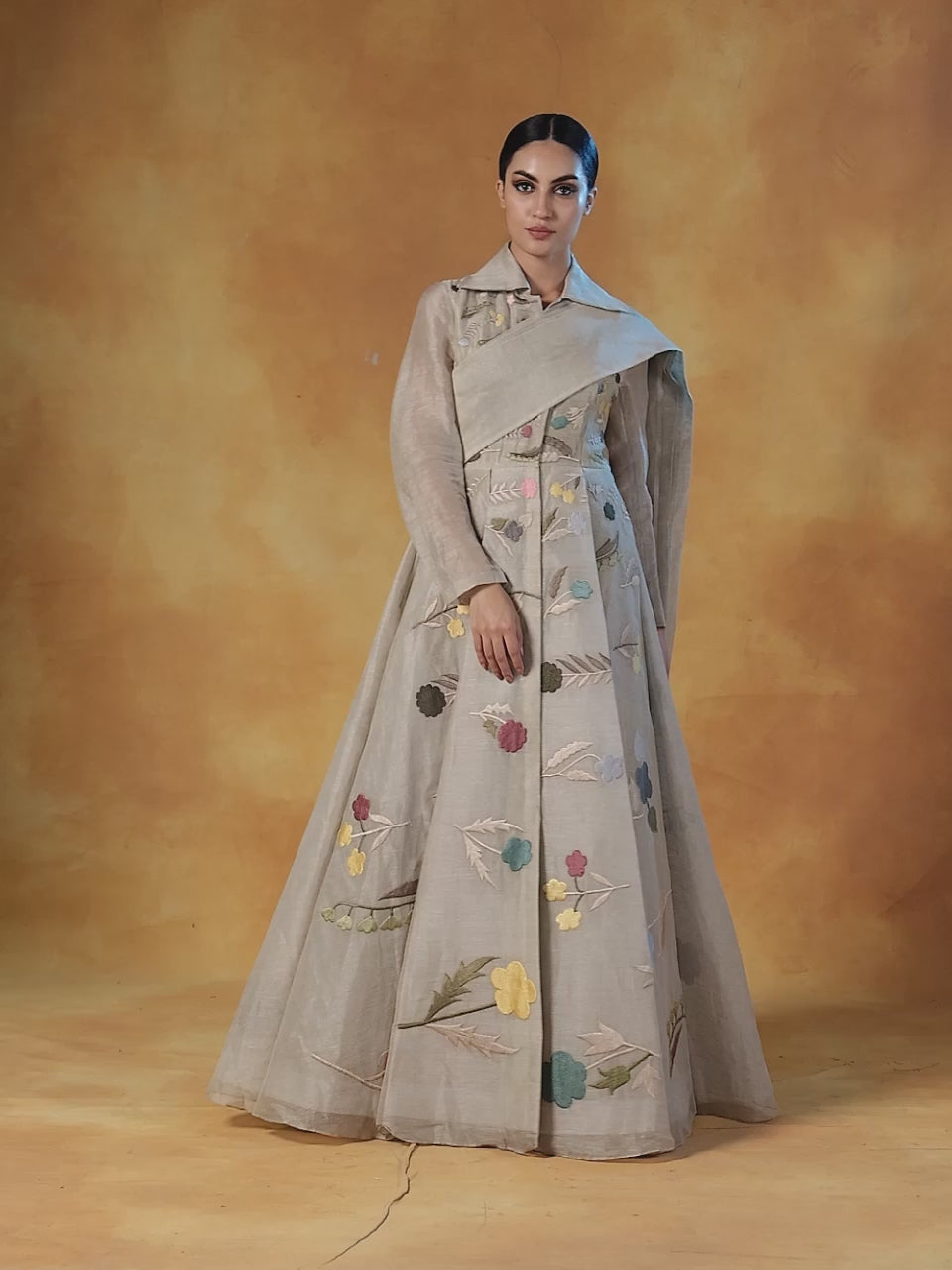 Embroidered A-line linen silk gown which has a collared neck with a pallu that is attached at the waist.