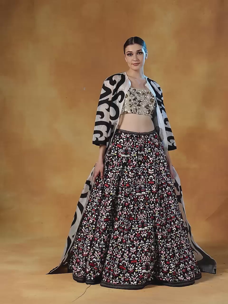 Organza jacket with black appliqué work, topped over a lehenga set