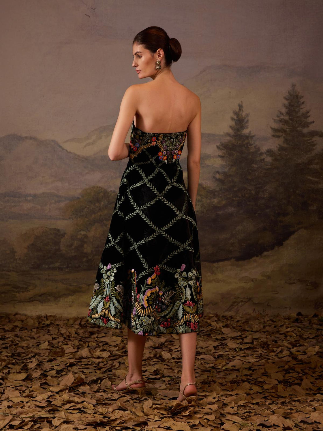 This strapless black midi dress features intricate floral embroidery.