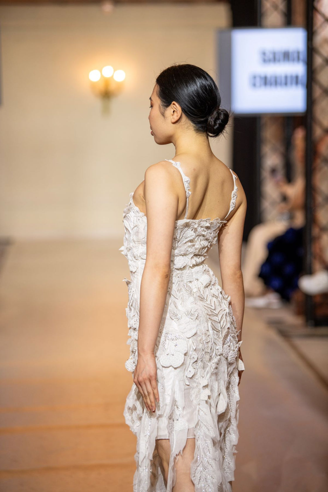 Turn heads in this strappy white gown featuring delicate 3D floral appliqués