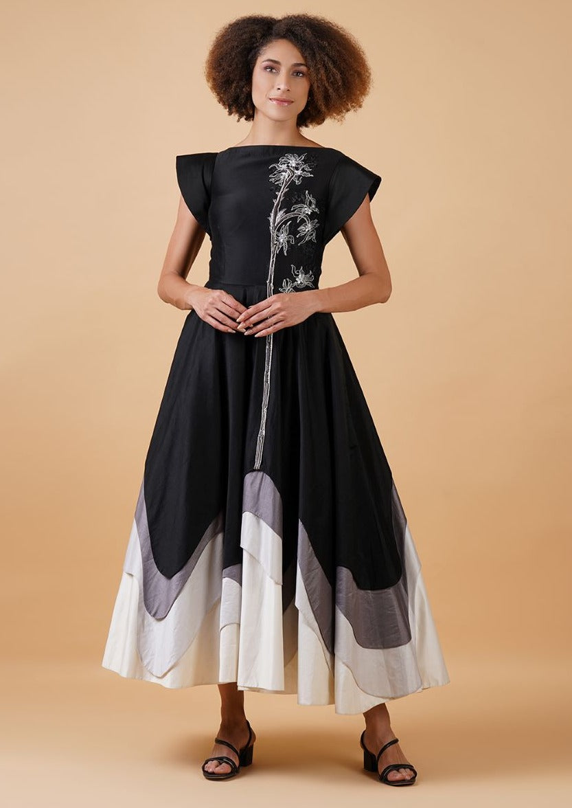 A black cotton silk, A-line dress that is given texture at the bottom