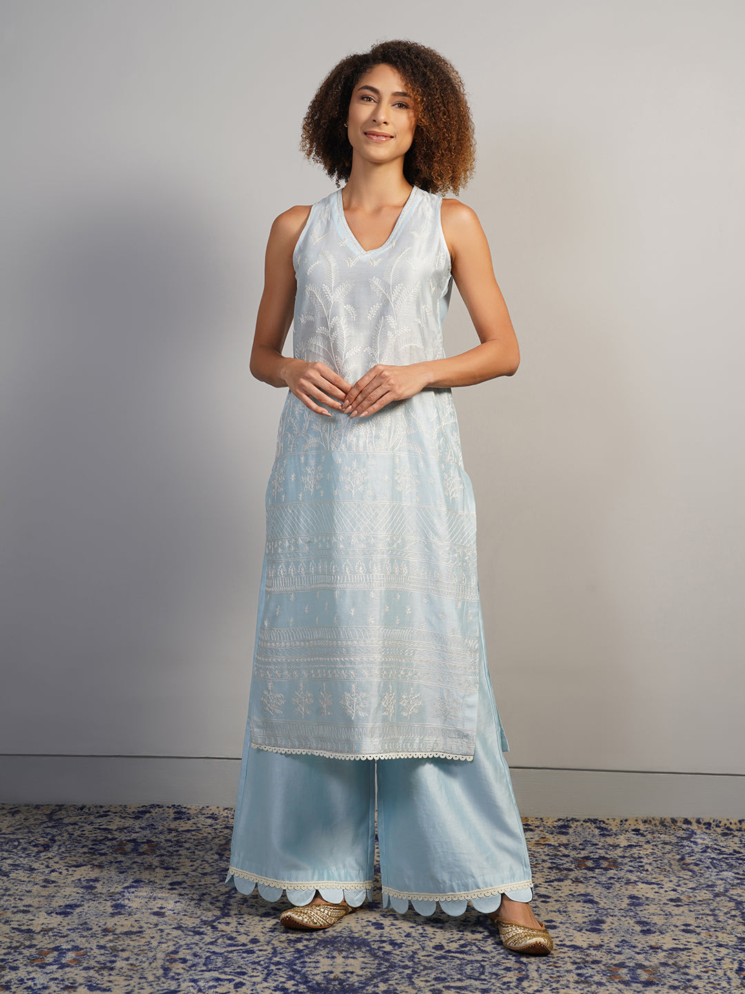 A V-neck, powder blue cotton silk suit set that is decorated subtly in Aari work embroidery