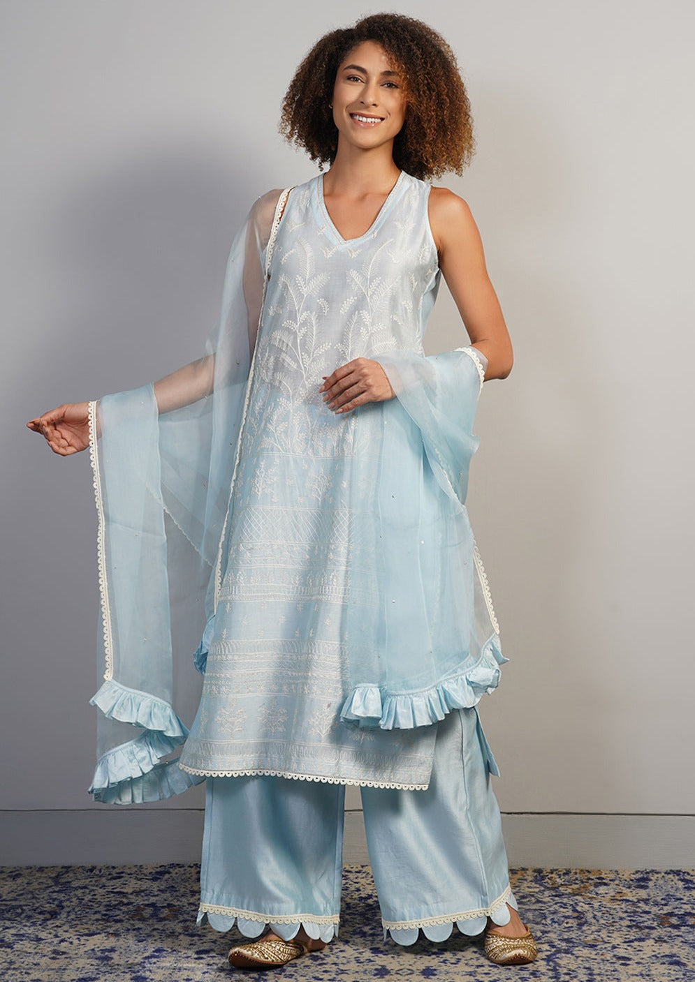 A V-neck, powder blue cotton silk suit set that is decorated subtly in Aari work embroidery