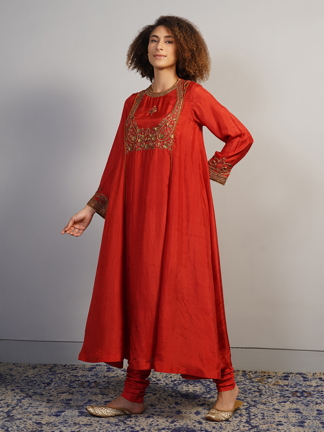 A rich looking, zero neck silk suit set in red that is intricately hand embroidered in zardozi