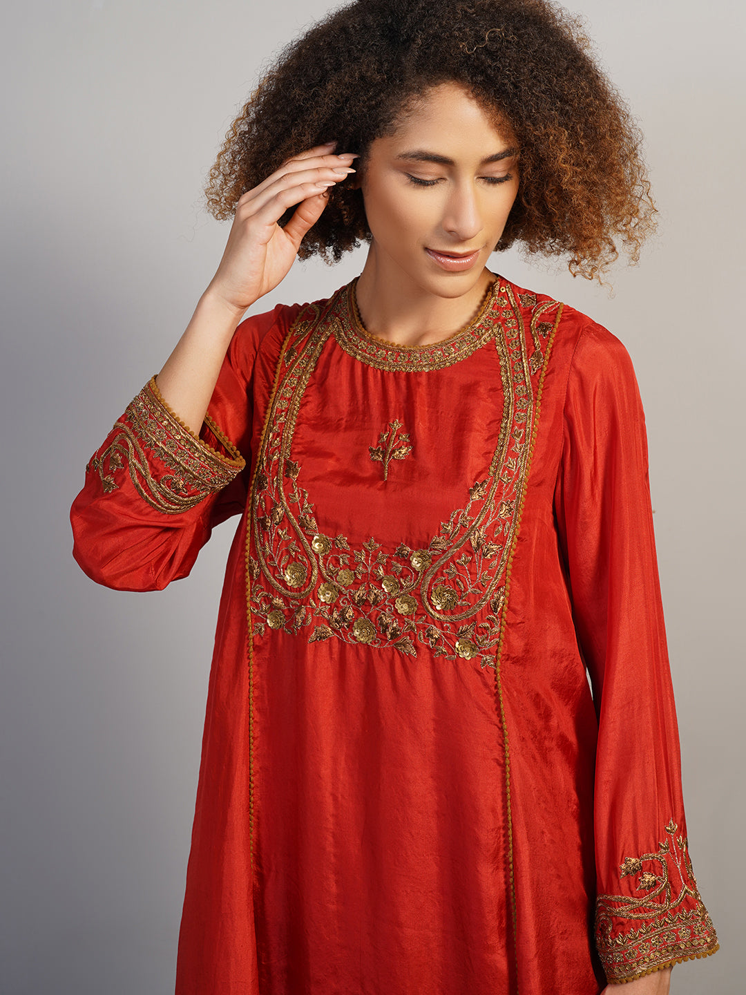 A rich looking, zero neck silk suit set in red that is intricately hand embroidered in zardozi