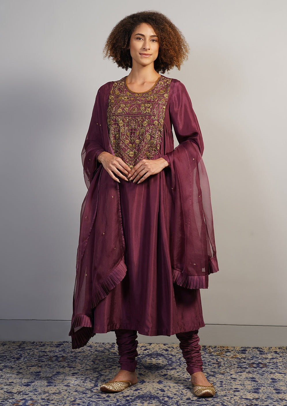 A beautiful deep wine A-line, round neck kurta set with gathers on the sides and intricate gold zardosi embroidery